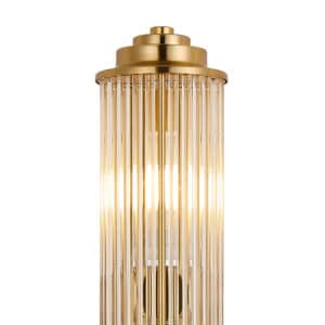 close up image of the top of a gold bathroom wall light with glass rods
